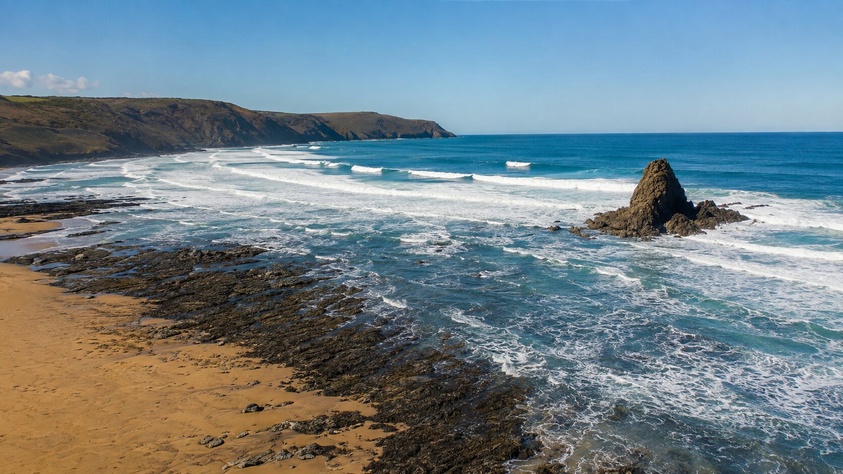 Sunny aerial view of Black Rock Beach facing the open Atlantic with large breaking waves