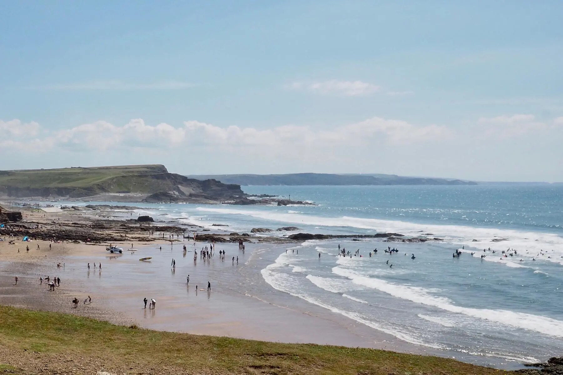 Surfers and families enjoying a sandy beach near Bude
