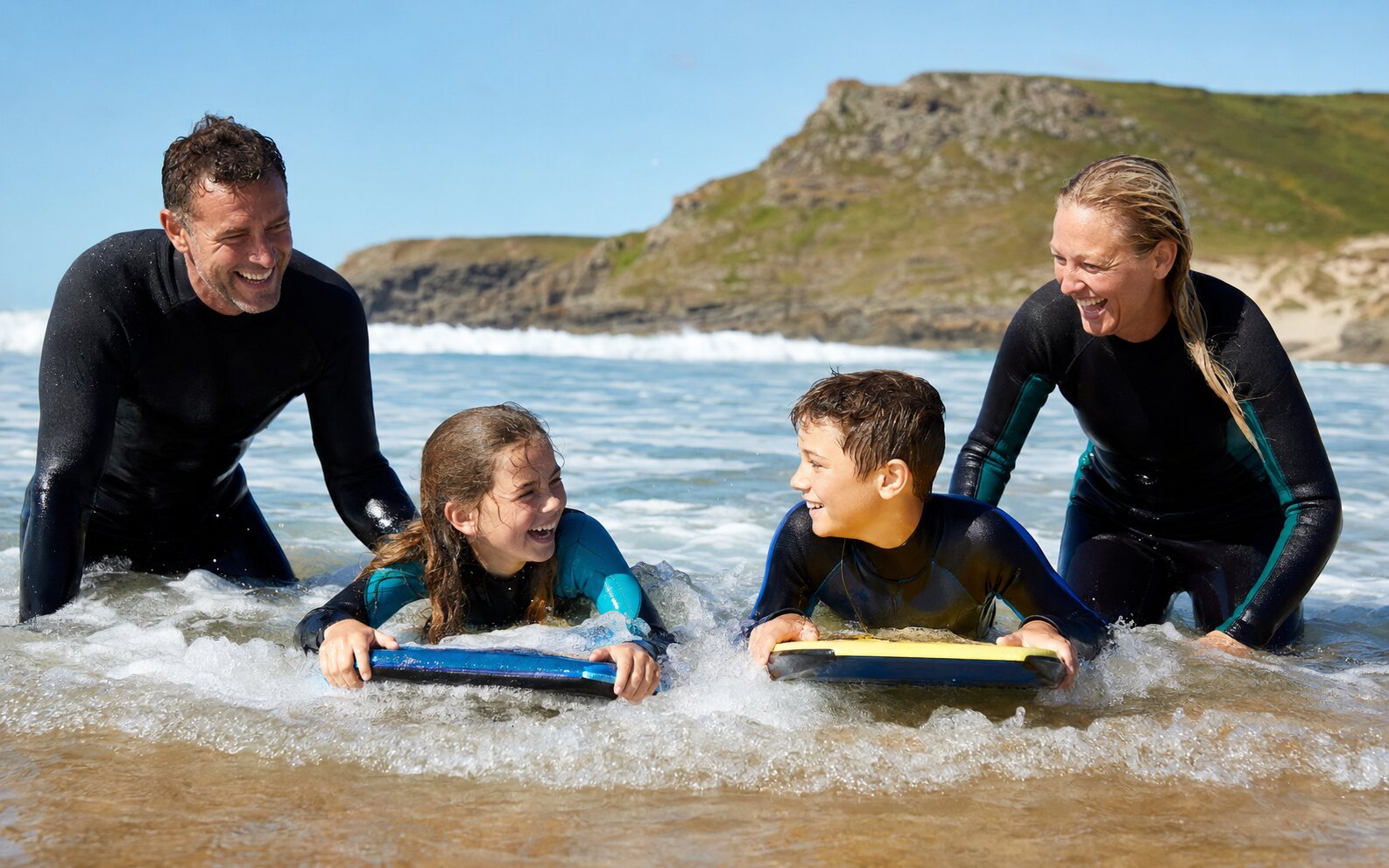 Family bodyboarding at Crooklets Beach in Bude