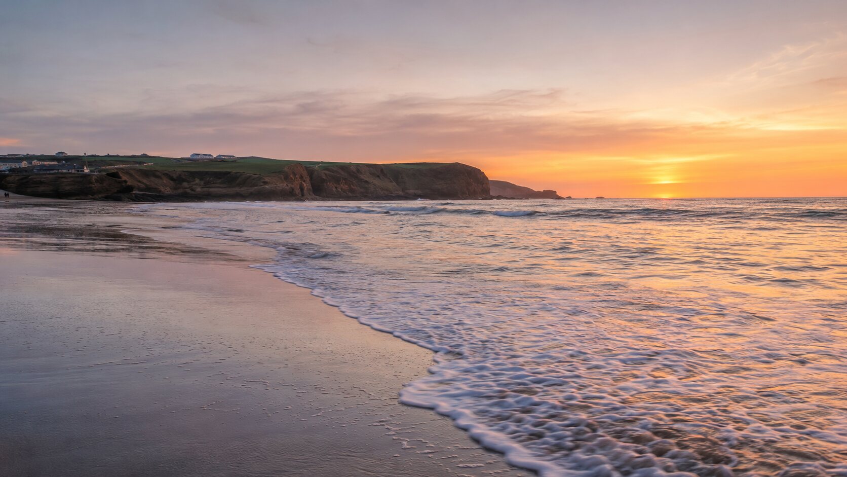 Crooklets Beach around high tide in warm golden-hour light