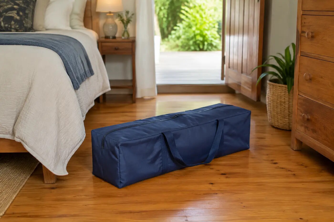 Blue bagged folding travel cot in a real holiday-home bedroom