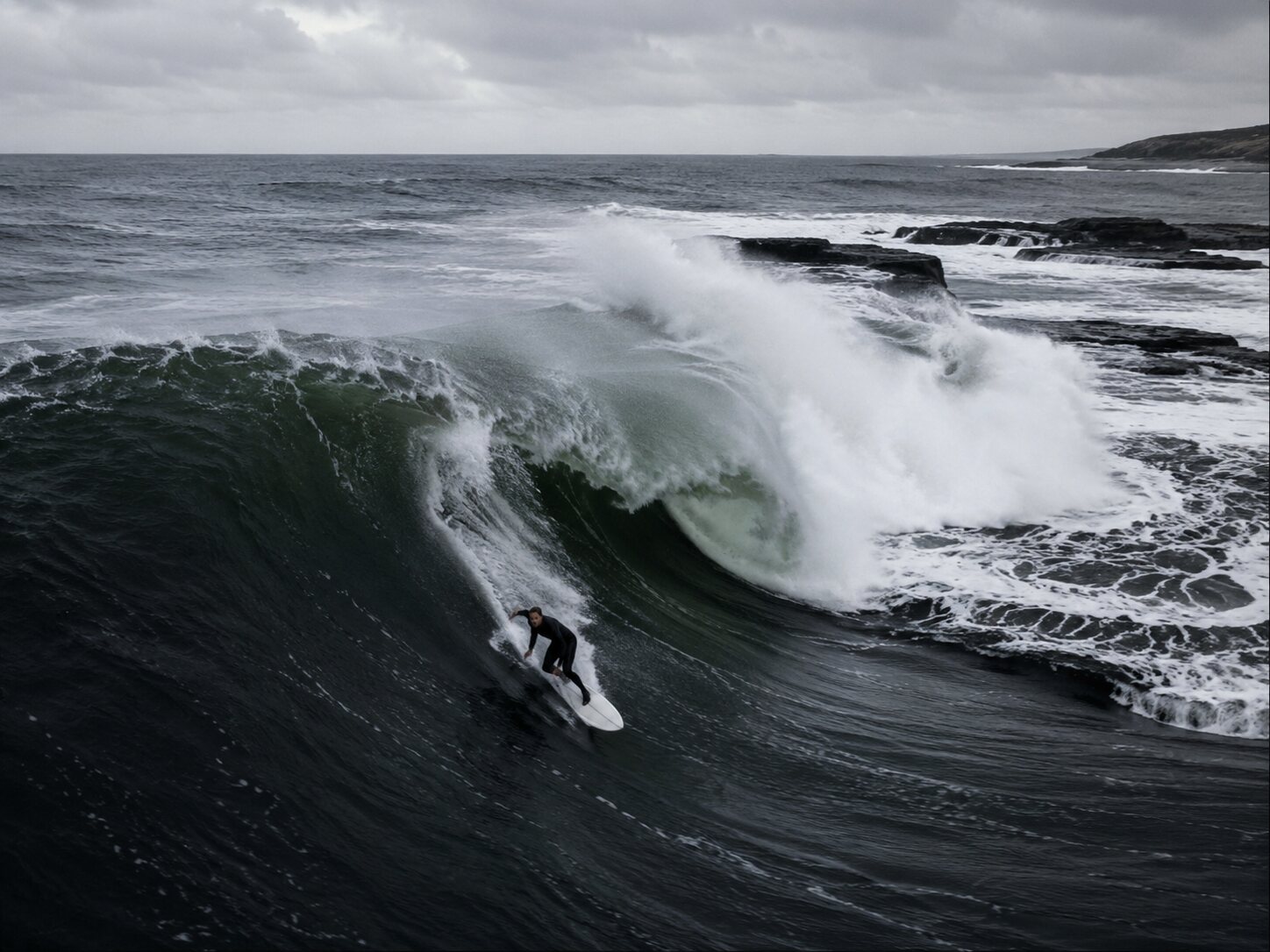 Representative expert surfer committed to a steep drop on a heavy North Atlantic slab