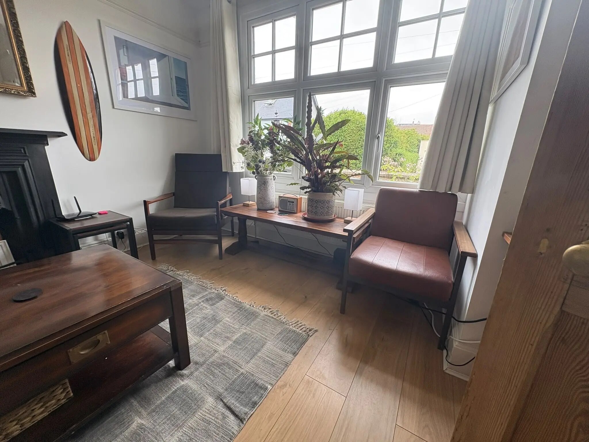 Spacious living room with sofa, fireplace and coastal artwork