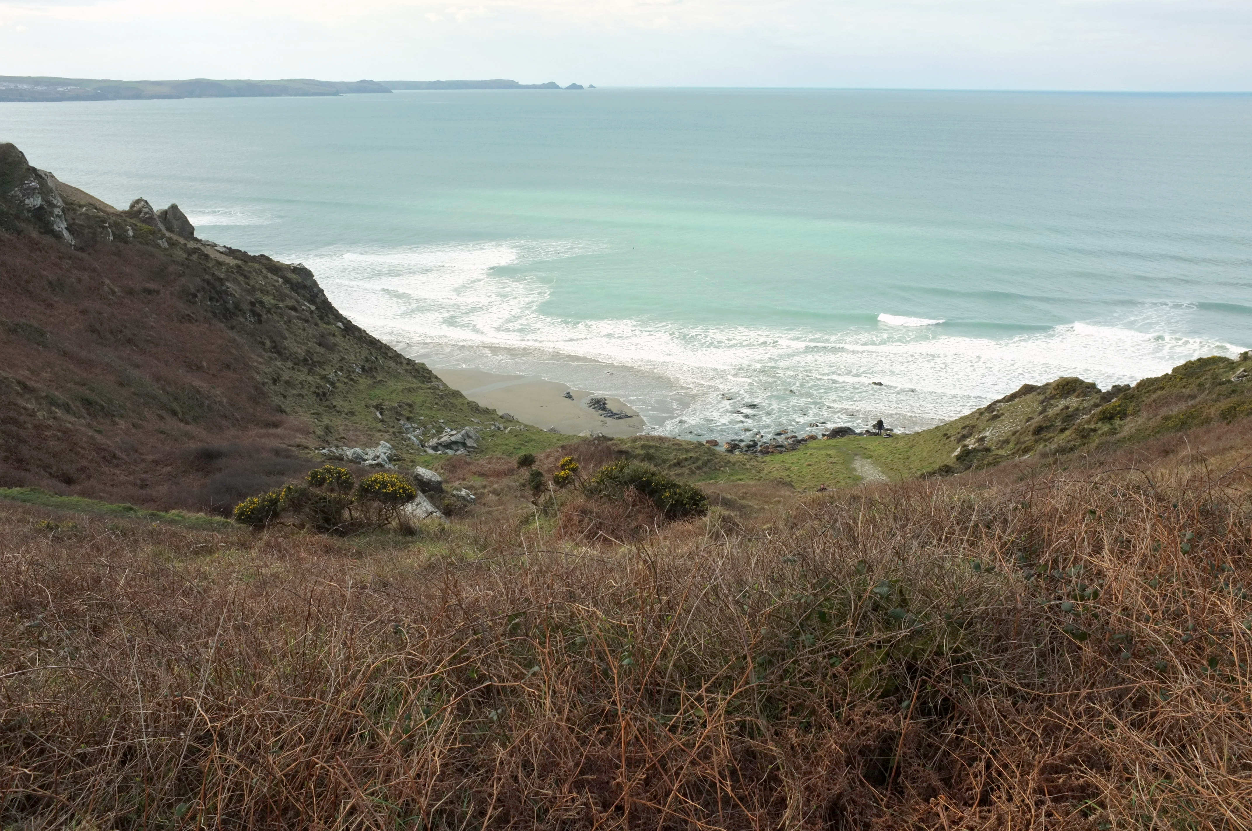 The steep wild descent to Tregardock Beach with Atlantic surf breaking below