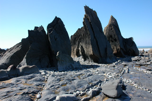 Jagged vertical rock fins exposed at low tide on Warren Gutter Beach